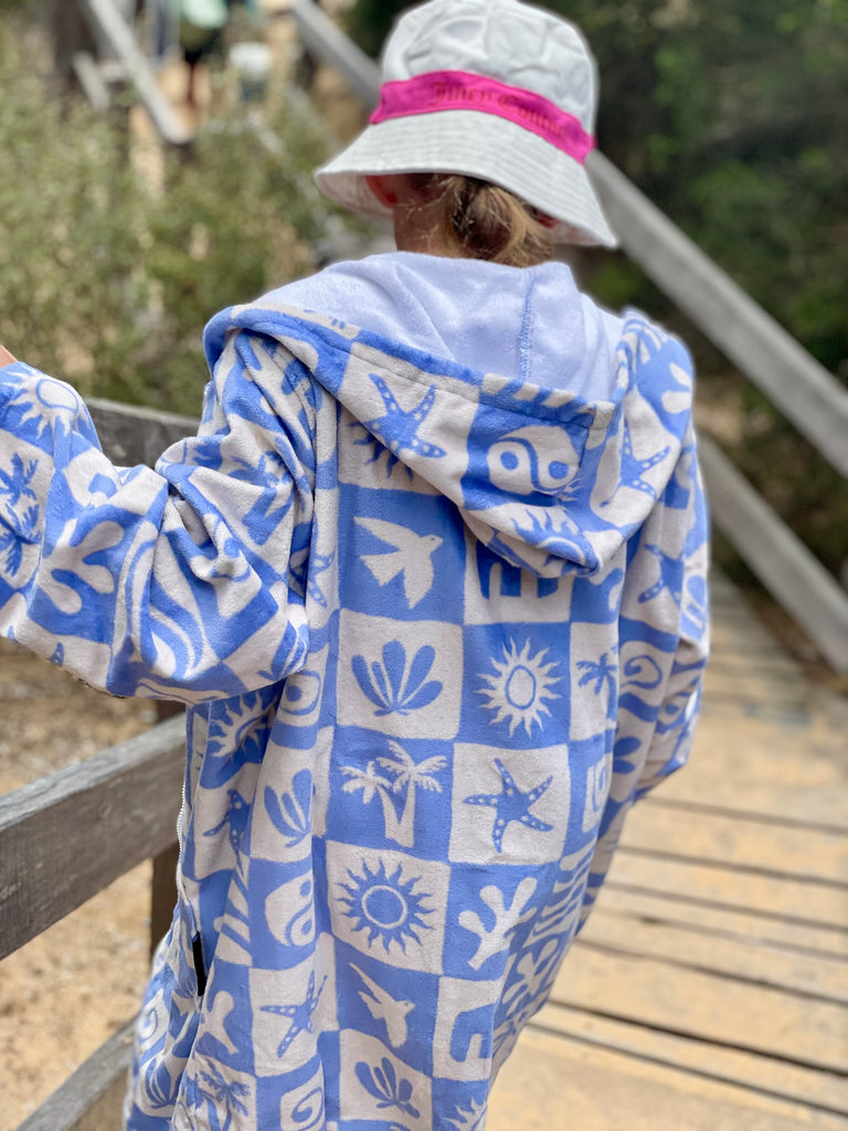 girl walking down stairs on beach wearing zip up towel