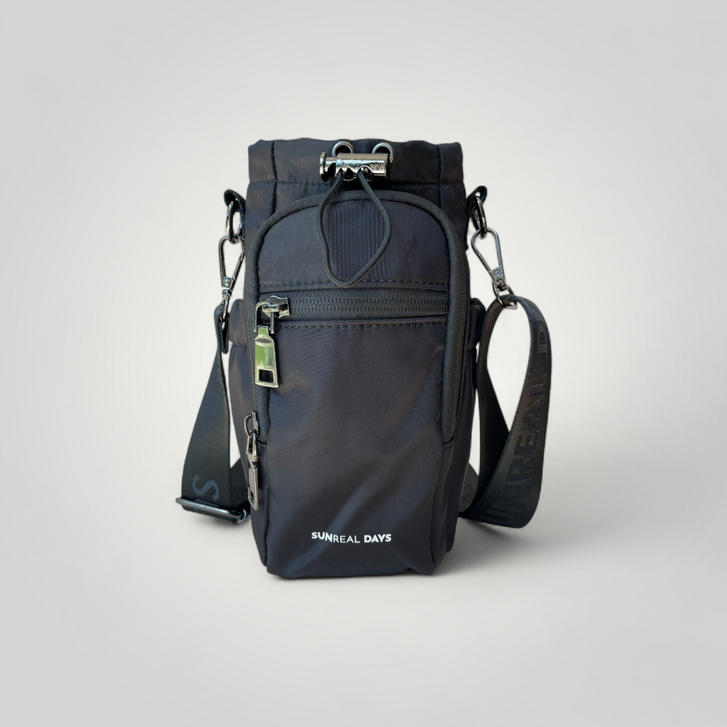 Black water bottle carry bag with gold accents and 'Sunreal Days' branding. Zipped pockets to hold phone and keys.