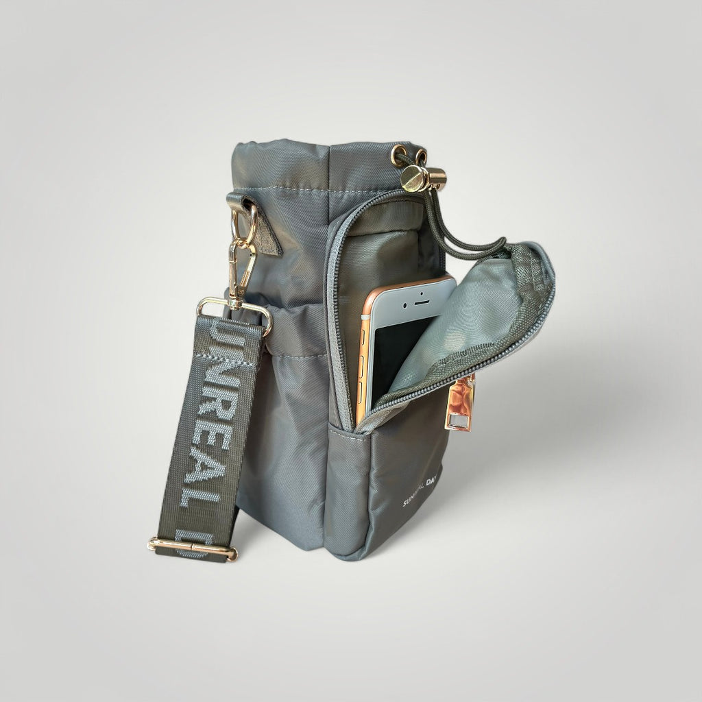 Khaki green water bottle carry bag with gold accents and 'Sunreal Days' branding. Zipped pockets to hold phone and keys.