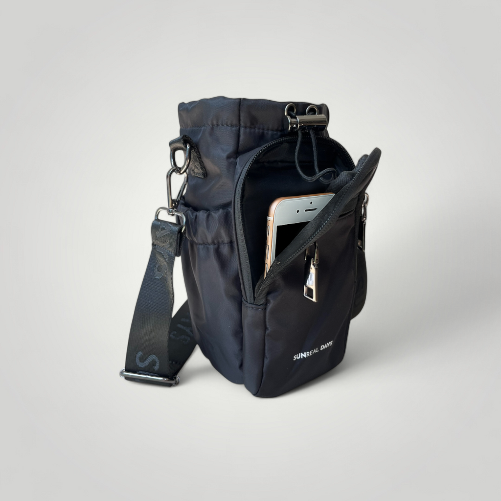 Black water bottle carry bag with gold accents and 'Sunreal Days' branding. Large zipped pockets to hold phone and keys.