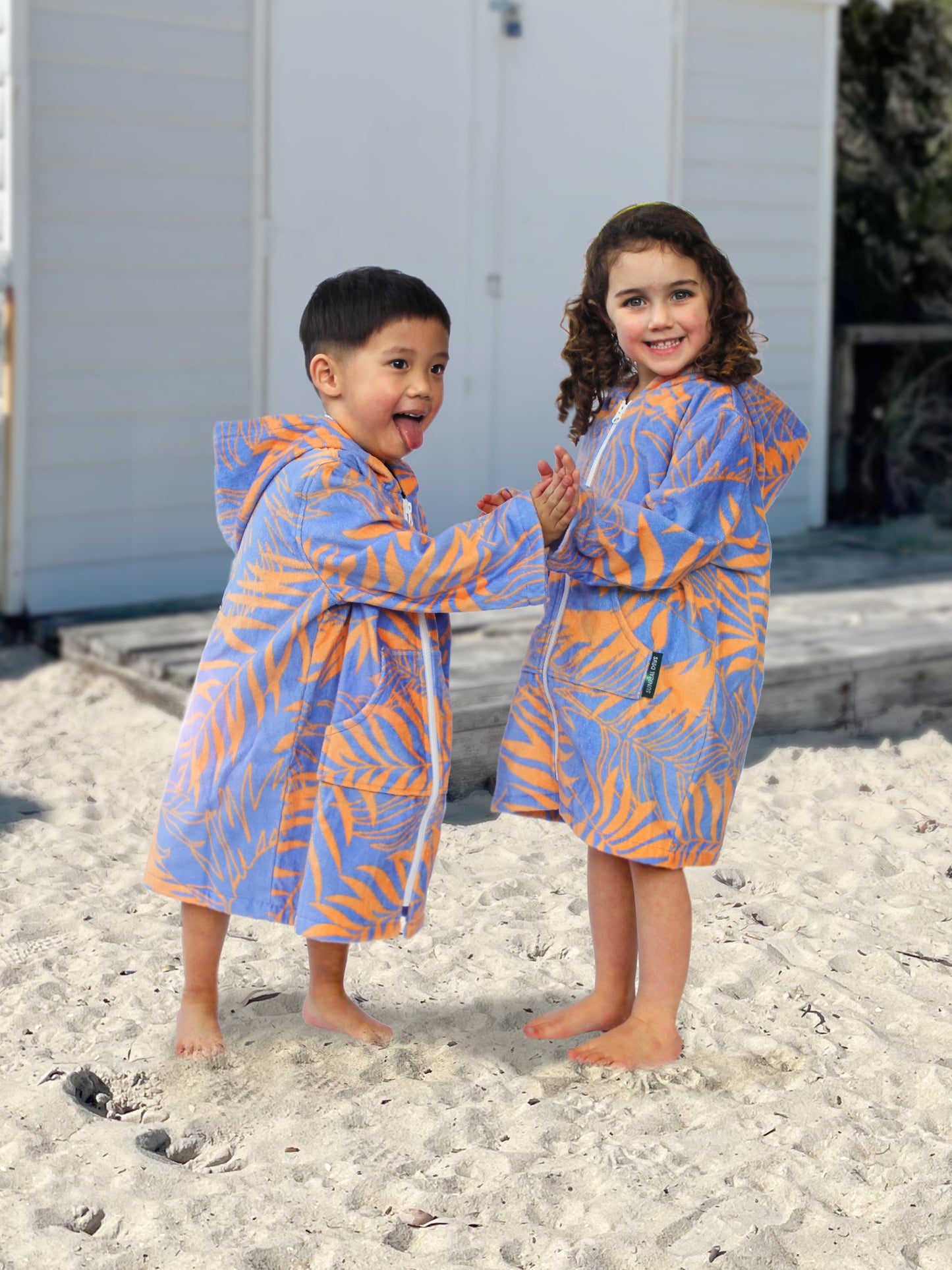 toddlers wearing swim jacket with zip on beach